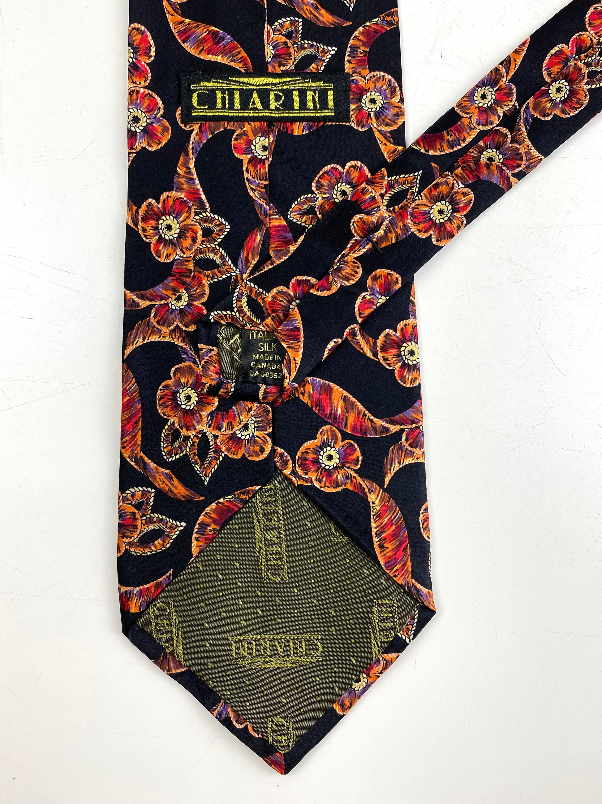 Back and labels of: 90s Deadstock Silk Necktie, Men's Vintage Black/ Orange/ Red Floral Ribbon Pattern Tie, NOS