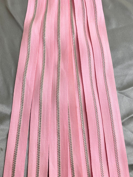 A batch of light pink metal zippers. Ian Drummond Vintage.