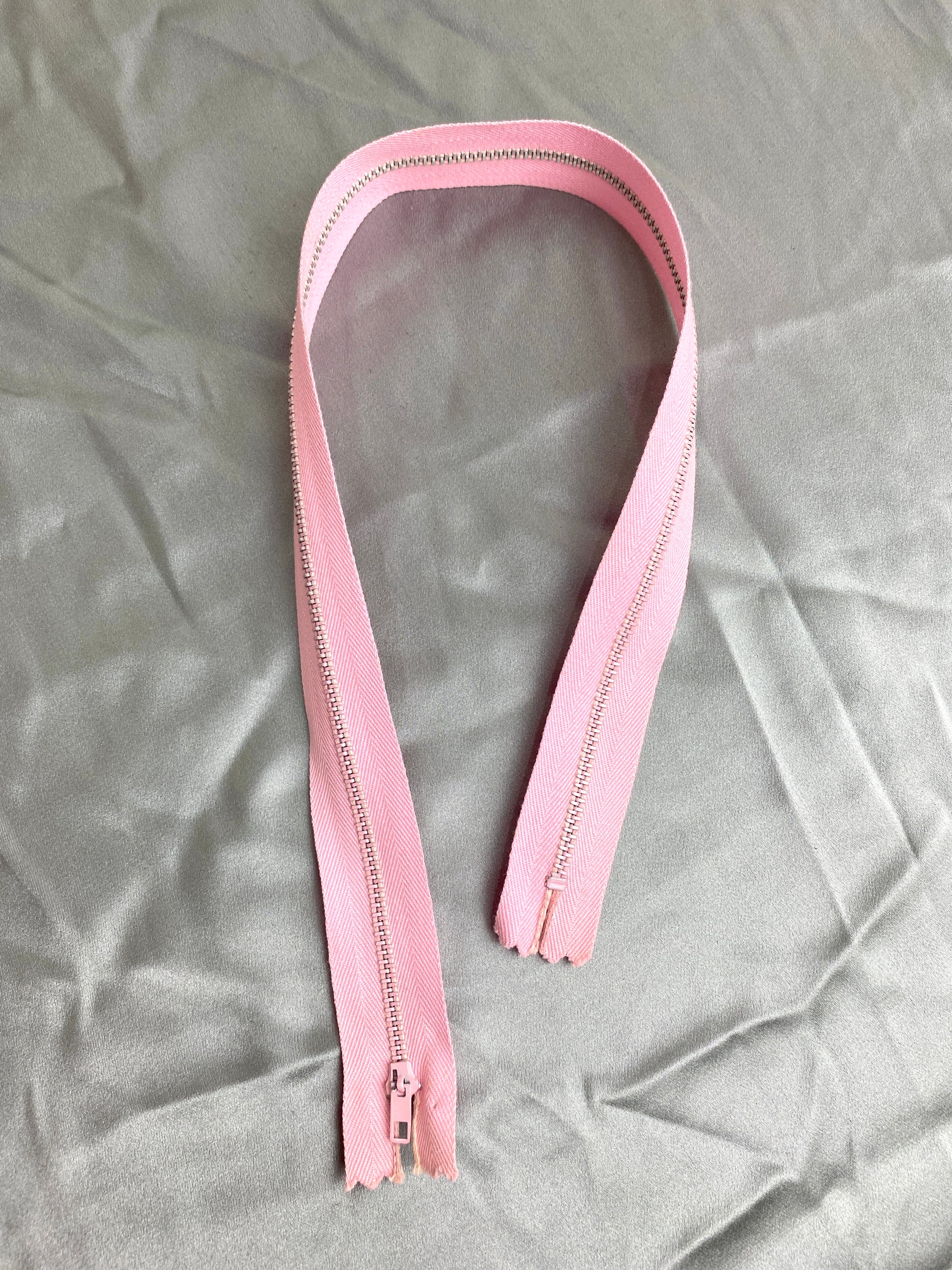 A single vintage pink metal zipper. Ian Drummond Vintage. 