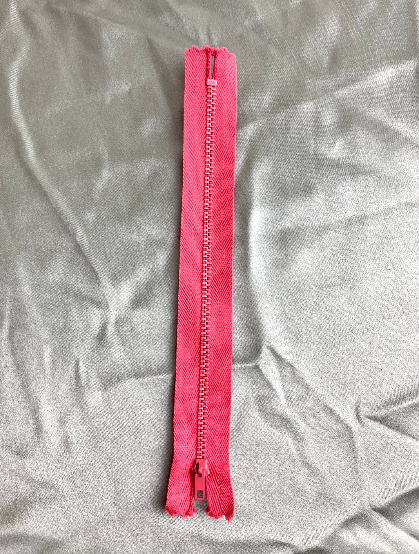 A single pink vintage metal zipper. Ian Drummond Vintage. 