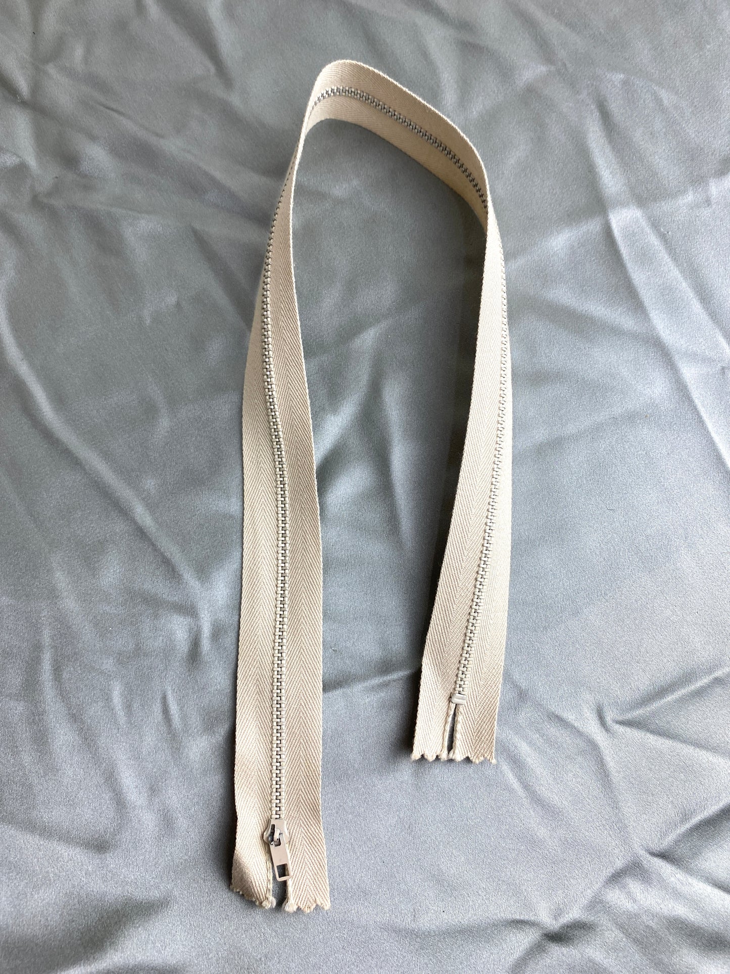 A single light tan vintage metal zipper. Ian Drummond Vintage. 