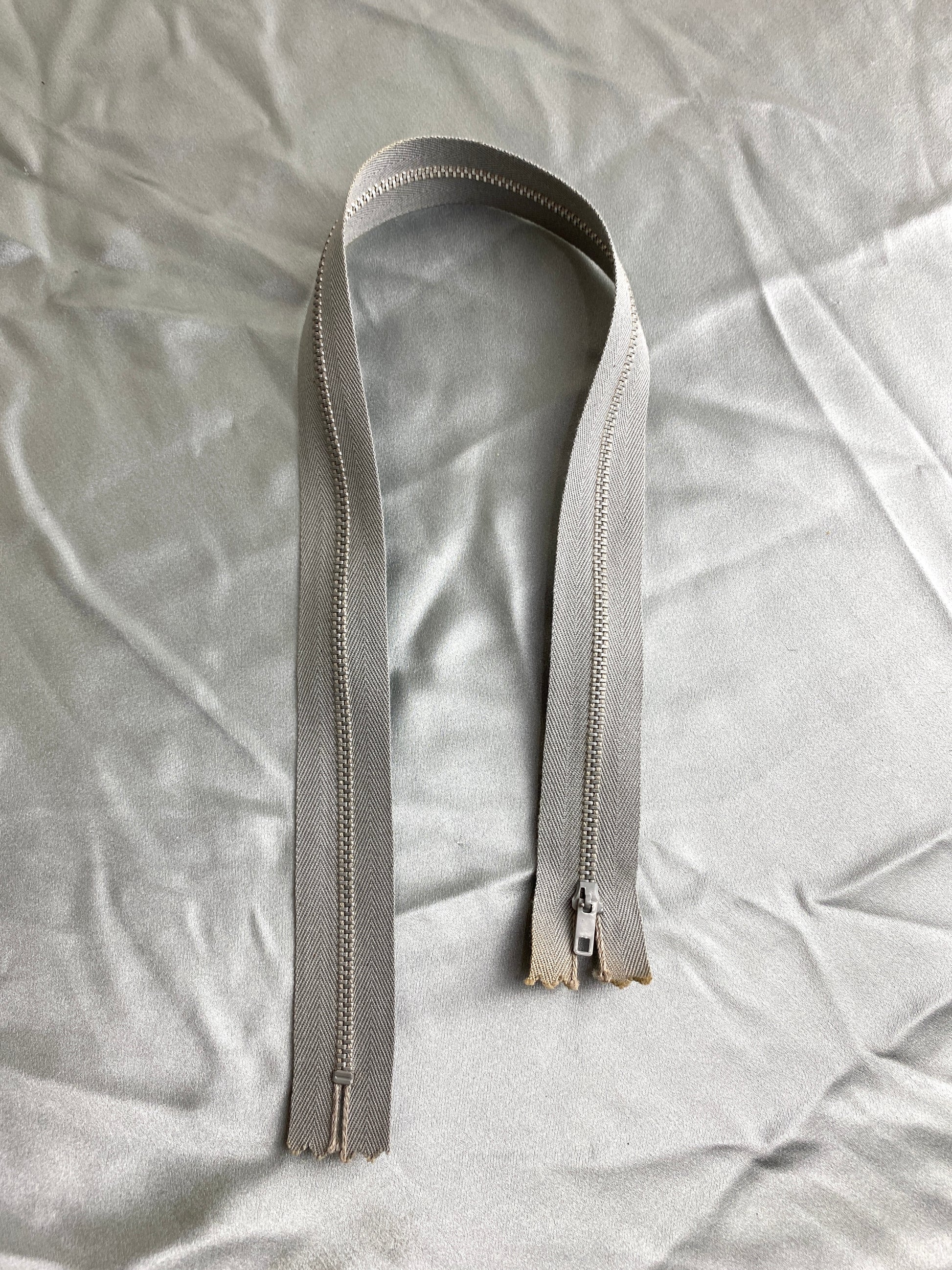 A single light grey zipper. Ian Drummond Vintage. 