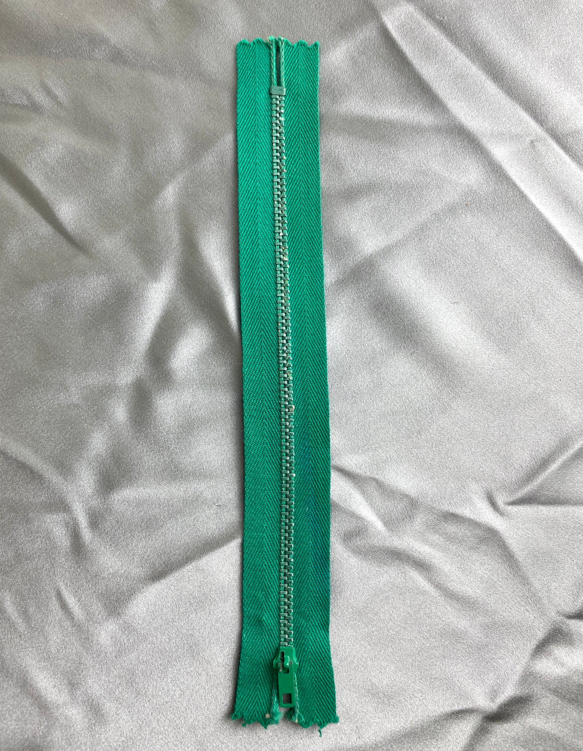 A single deep green metal vintage zipper. Ian Drummond Vintage. 