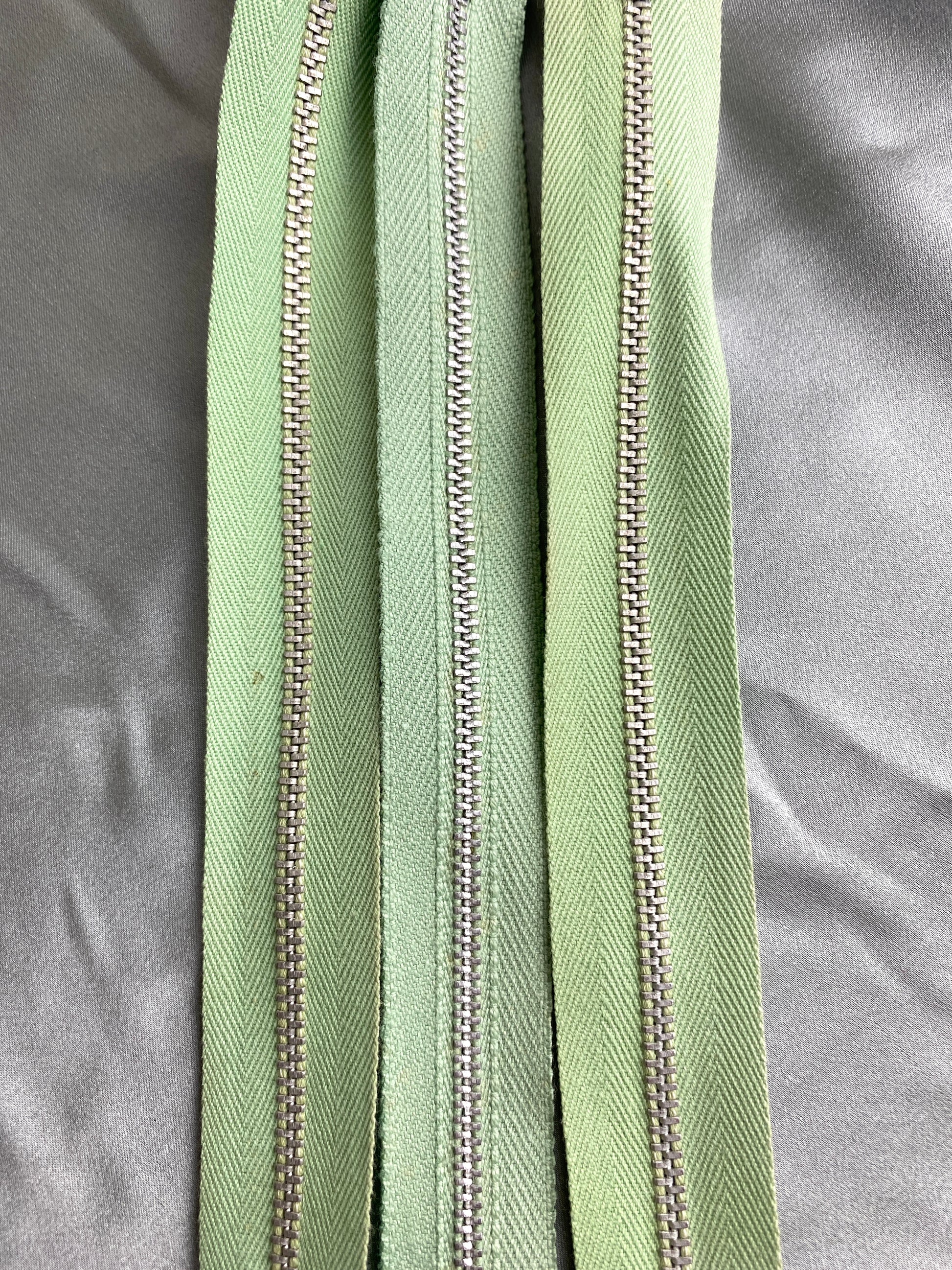 A batch of light green metal zippers. Ian Drummond Vintage. 