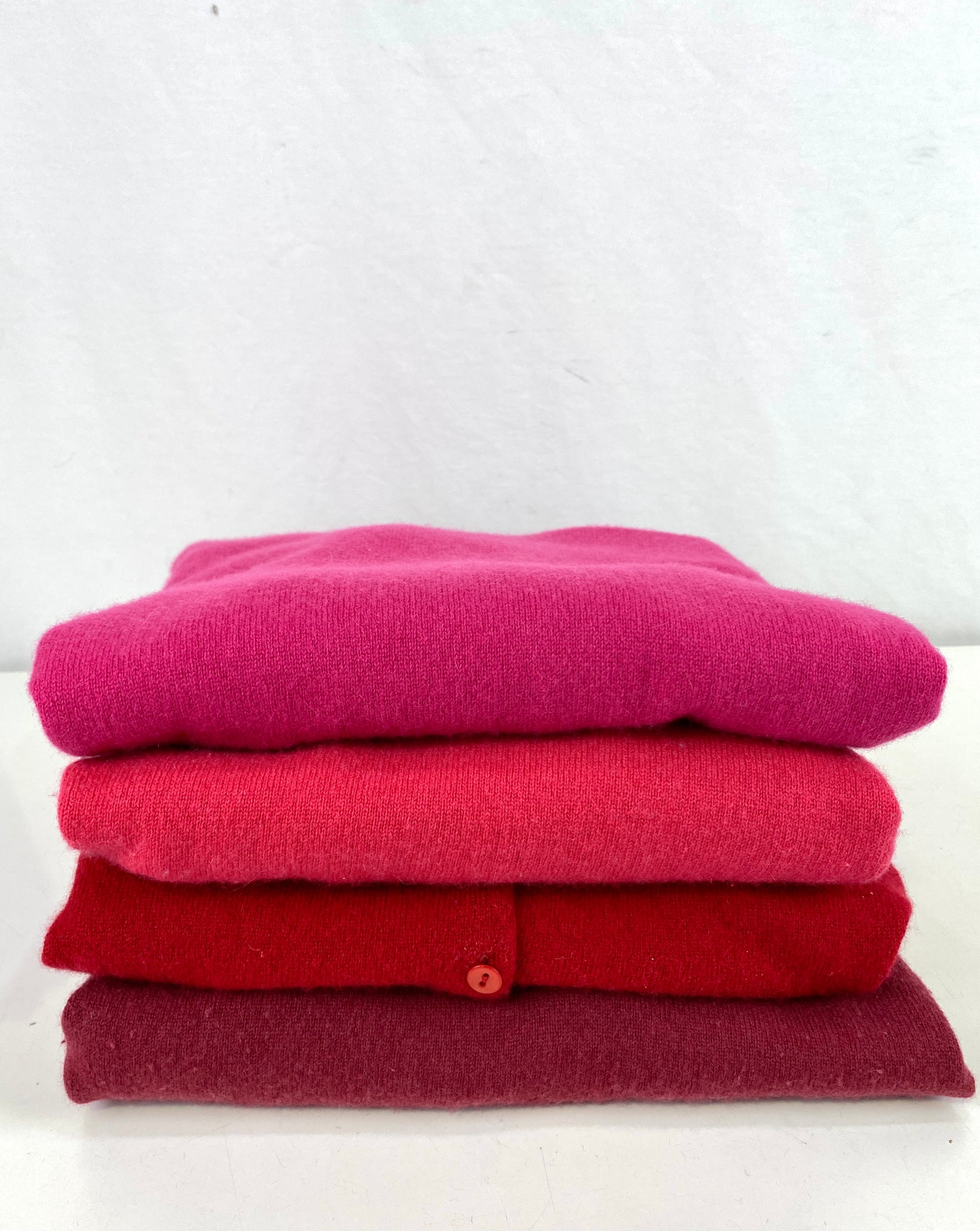 A stack of 4 pink and red cashmere sweaters. Ian Drummond Vintage.  