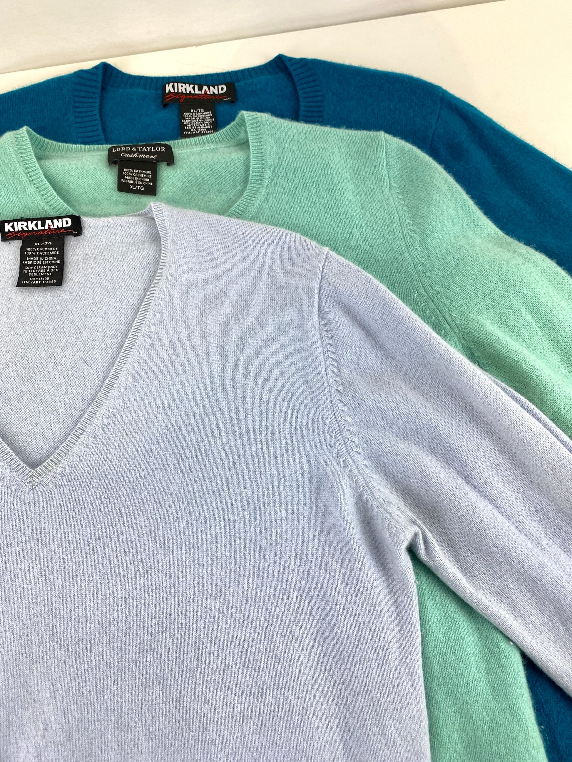 3 cashmere sweater laying flat. teal, blue, mint. Ian Drummond Vintage.