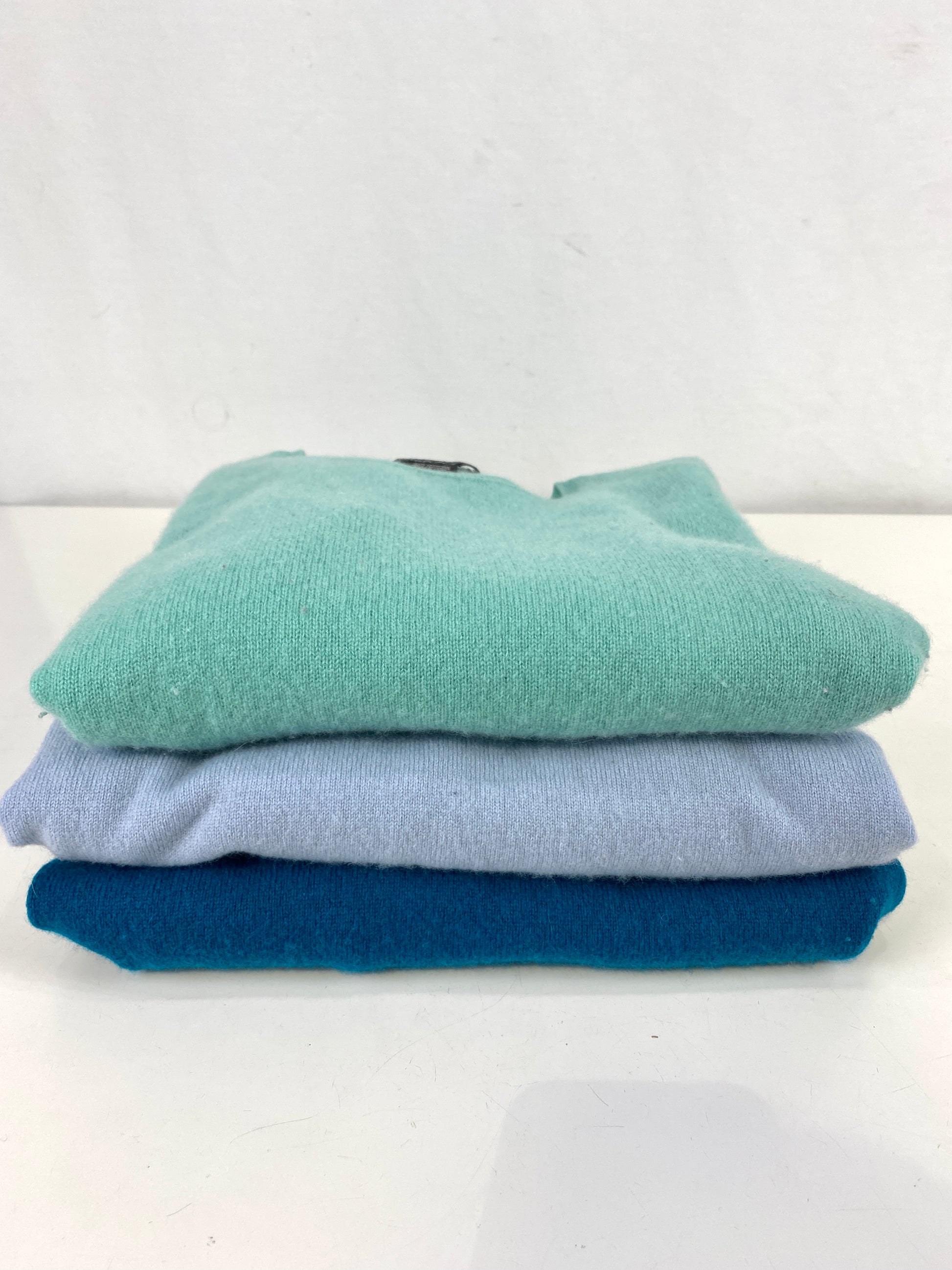 3 blue & green cashmere knits folded in a stack. Ian Drummond Vintage. 