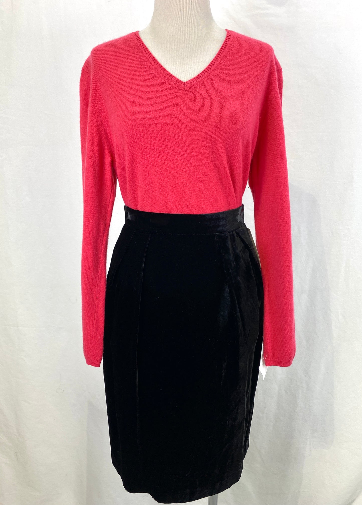 Pink V-neck vintage cashmere sweater tucked into a black skirt. Ian Drummond Vintage. 