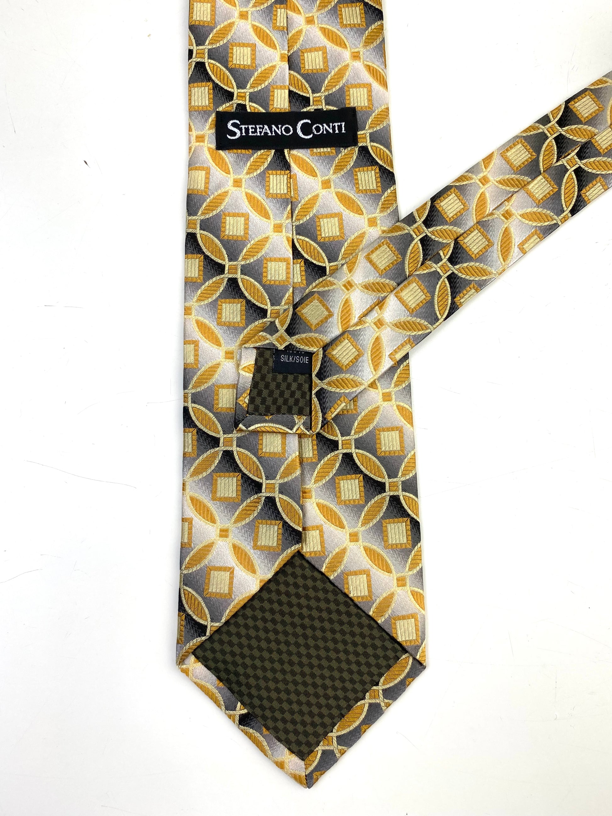 Back and labels of: 90s Deadstock Silk Necktie, Men's Vintage Gold Grey Medallion With Diagonal Stripe Pattern Tie, NOS
