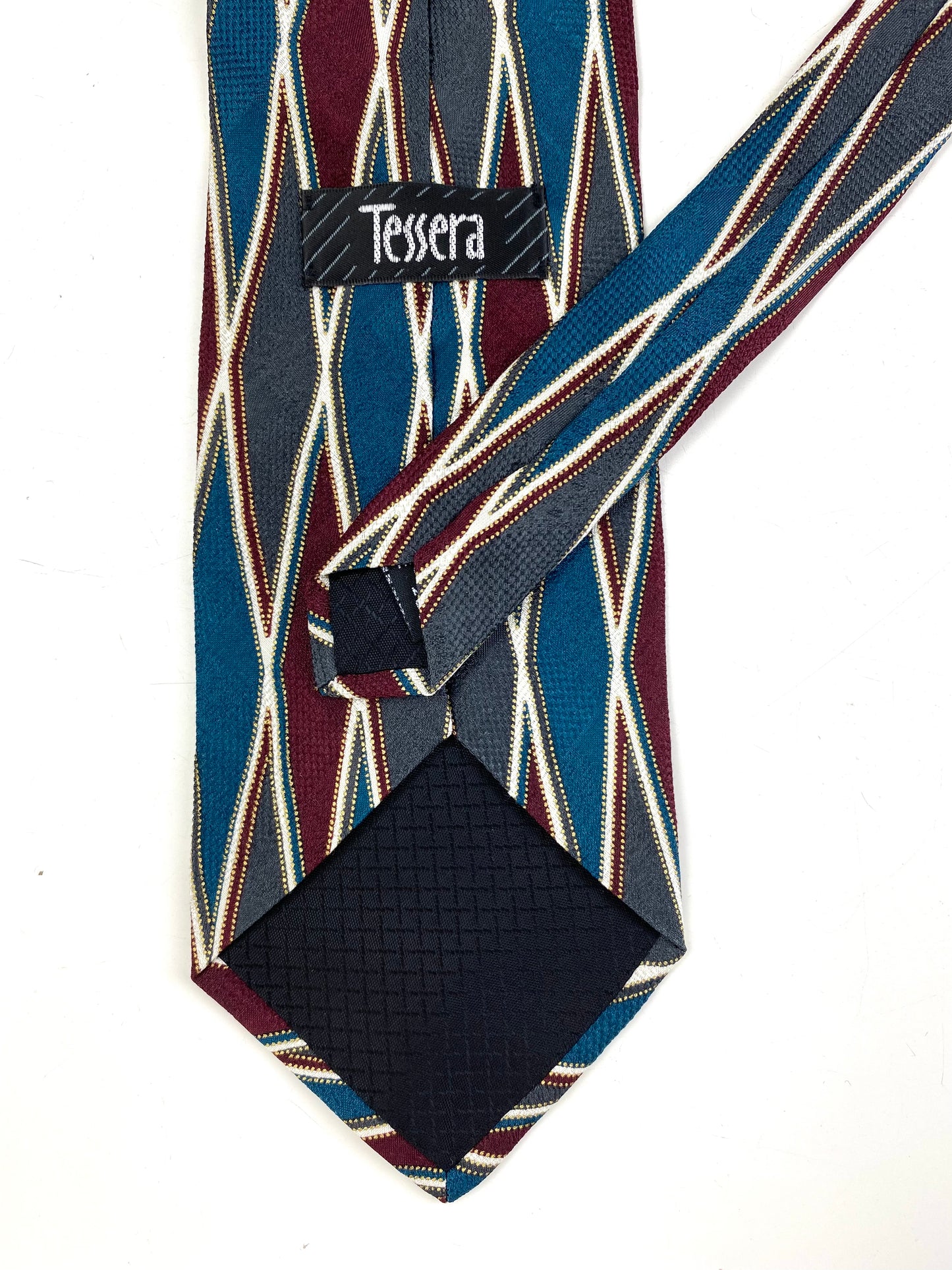 Back and labels of: 90s Deadstock Silk Necktie, Men's Vintage Teal/ Maroon/ Grey Diamond Harlequin Pattern Tie, NOS