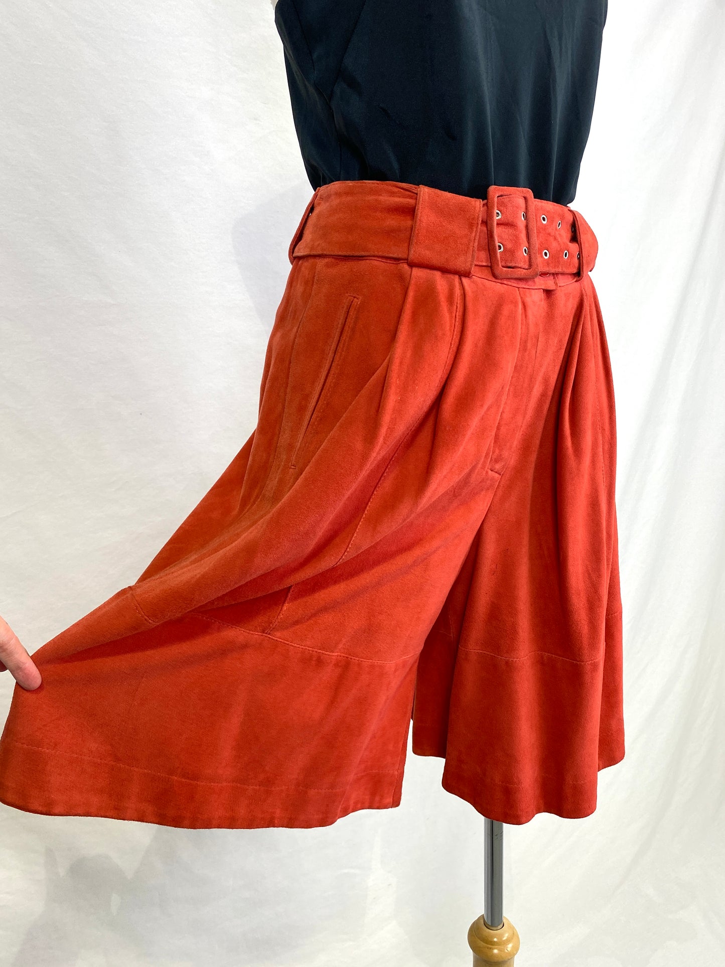 Vtg 90s rust suede culottes with wide leg held out. Ian Drummond Vintage. 