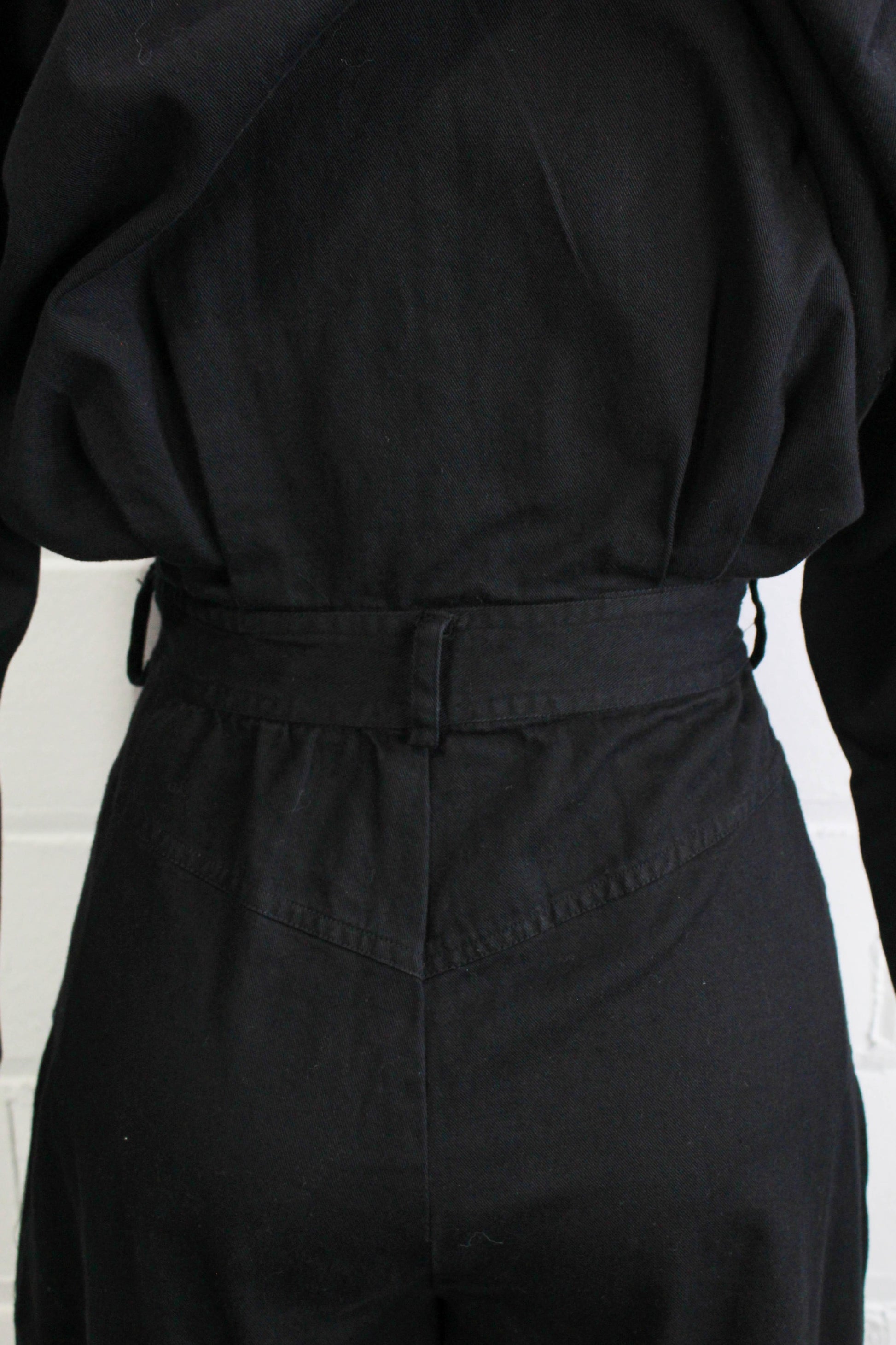 1980s womens jumpsuit black cotton with bib front, collar button up back view waist close up